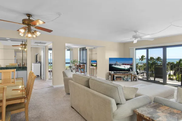 a living room with furniture a ceiling fan and a flat screen tv