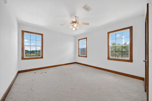 an empty room with windows and closet