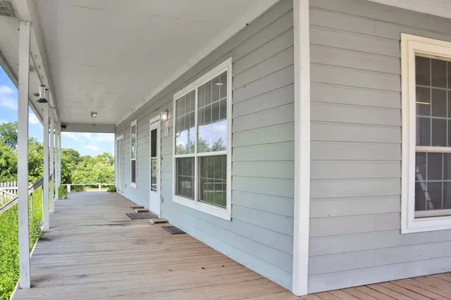 a view of a house with a big yard and large trees