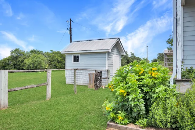 a view of a house with a big yard and large trees