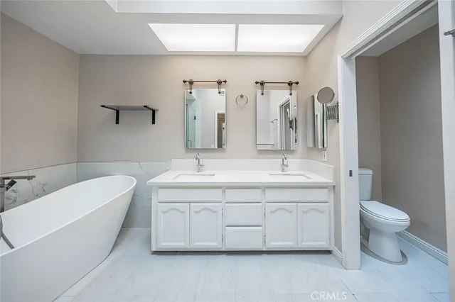 a spacious bathroom with a double vanity sink mirror and toilet