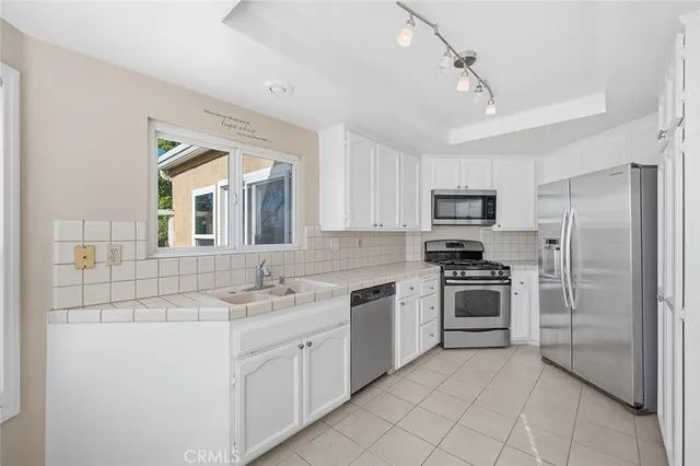 a kitchen with stainless steel appliances granite countertop a sink and stove top oven