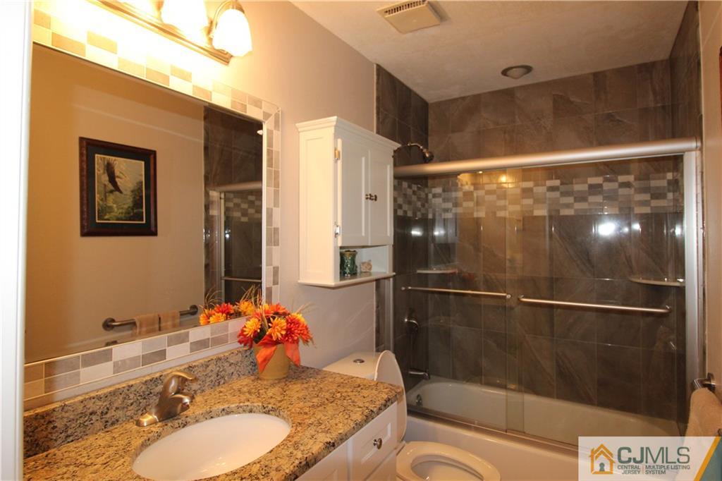 438 A Belford Road Monroe Township, NJ 08831 - Photo 12 of 19 a bathroom with a granite countertop sink a mirror and shower