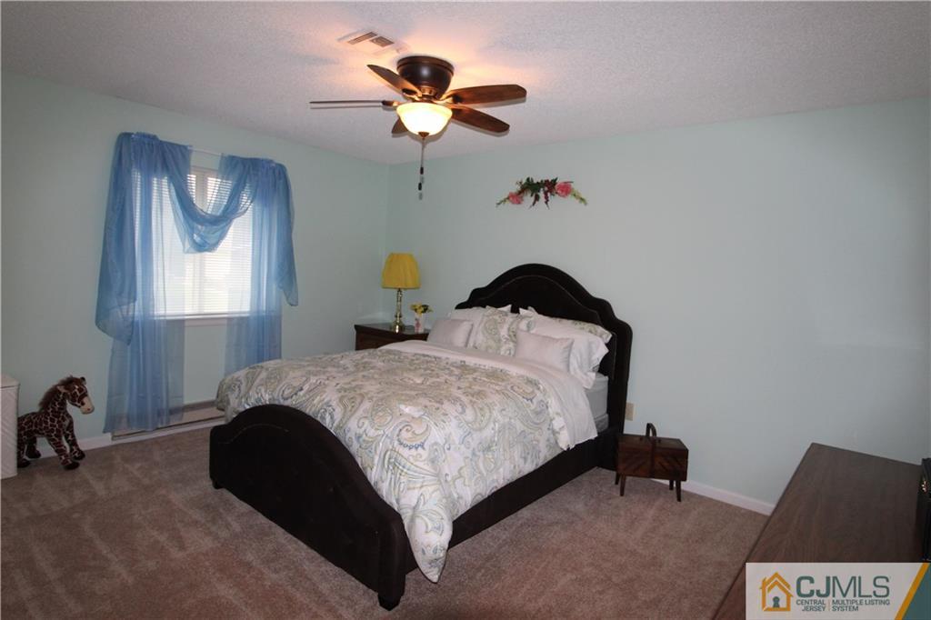 438 A Belford Road Monroe Township, NJ 08831 - Photo 13 of 19 a bedroom with a bed and a chandelier