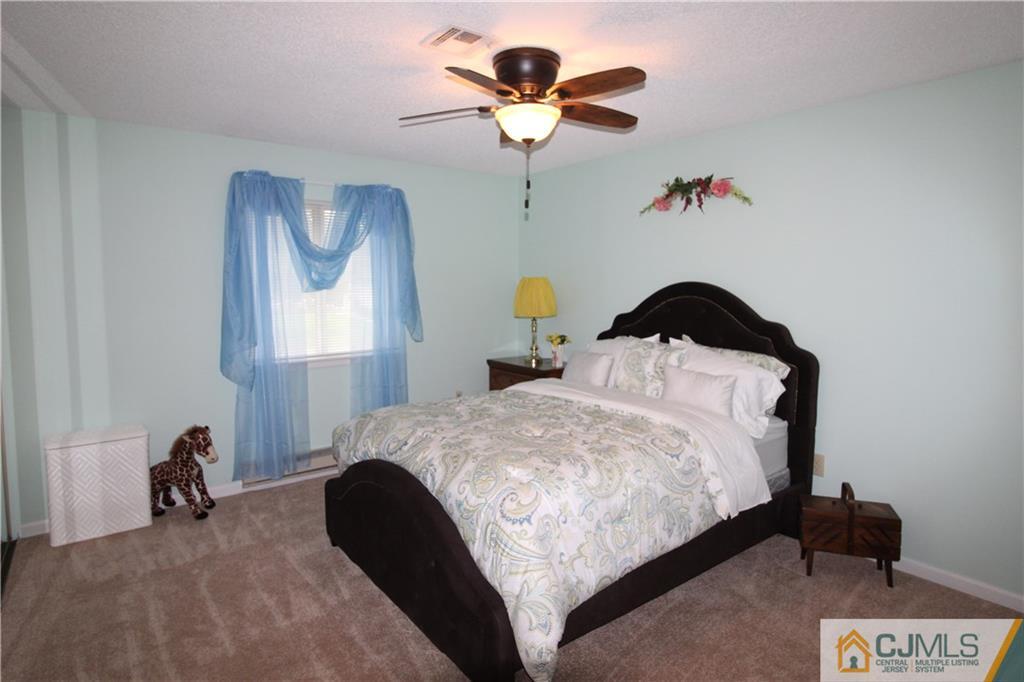 438 A Belford Road Monroe Township, NJ 08831 - Photo 15 of 19 a bedroom with a bed and a chandelier