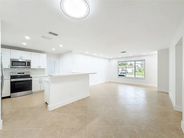 a kitchen with refrigerator and window