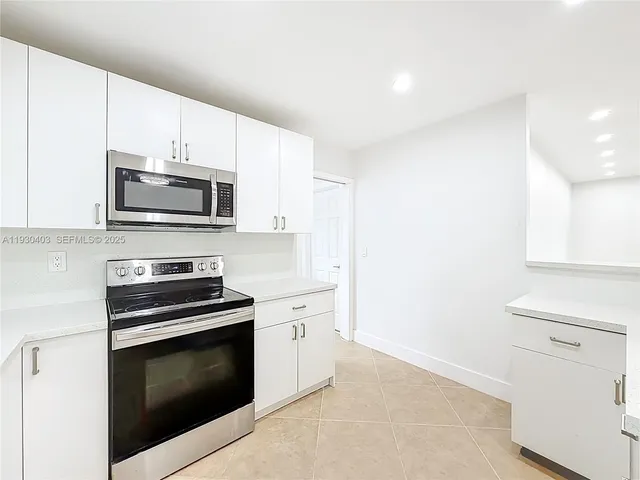 a kitchen with cabinets stainless steel appliances and sink