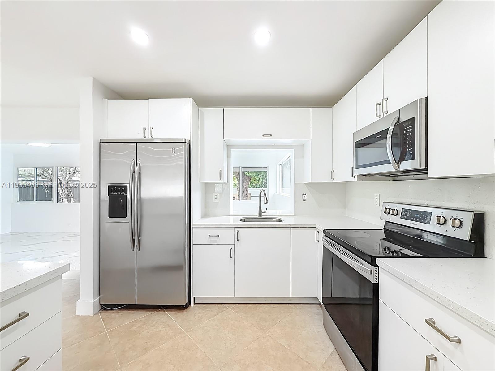 4008 Adams Street Hollywood, FL 33021 - Photo 16 of 54 a kitchen with stainless steel appliances a refrigerator sink and microwave