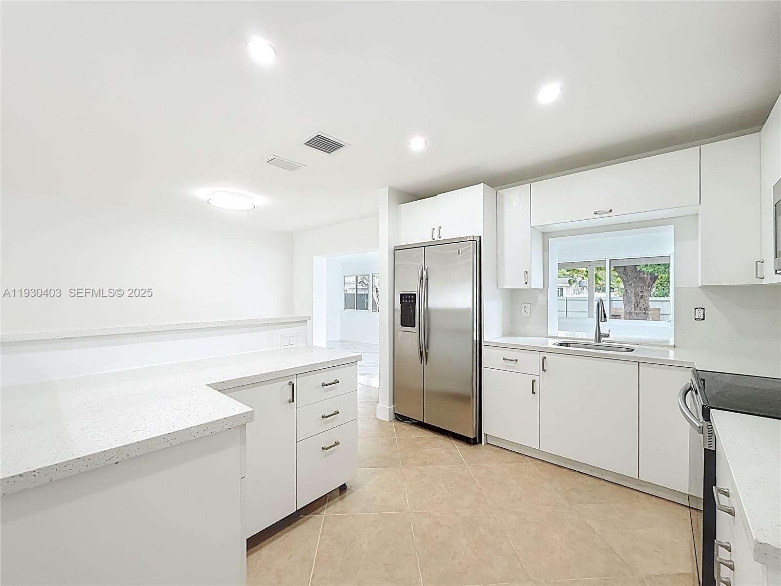 4008 Adams Street Hollywood, FL 33021 - Photo 17 of 54 a kitchen with white cabinets and stainless steel appliances