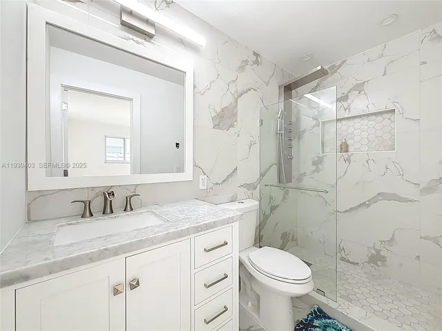 a bathroom with a double vanity sink toilet mirror and shower