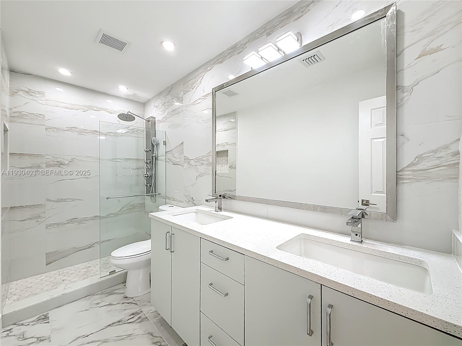 4008 Adams Street Hollywood, FL 33021 - Photo 27 of 54 a bathroom with a double vanity sink toilet mirror and shower