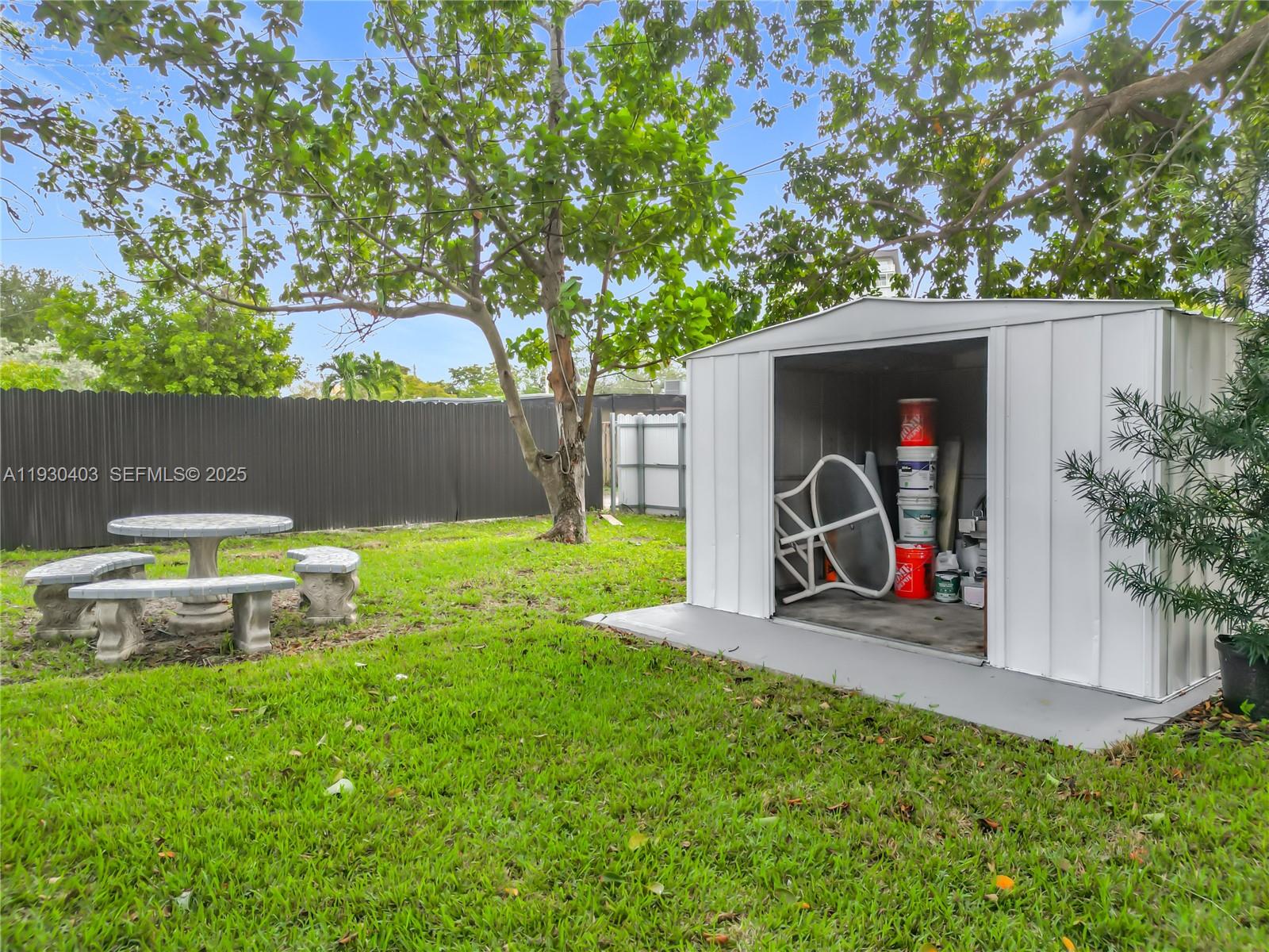 4008 Adams Street Hollywood, FL 33021 - Photo 47 of 54 a view of a backyard with table and chairs and a large tree