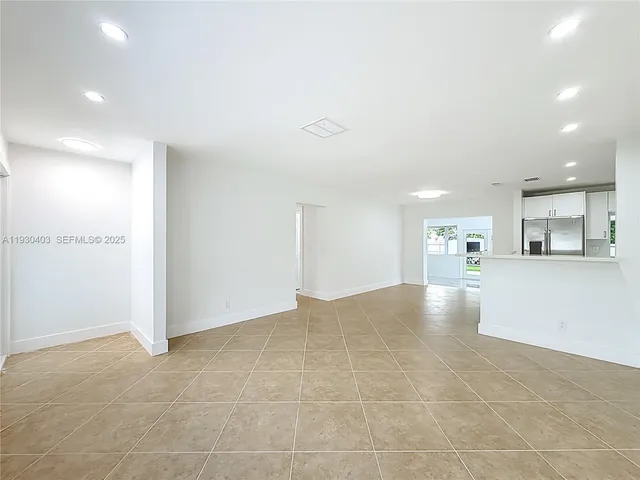 a view of a kitchen with kitchen island and stainless steel appliances