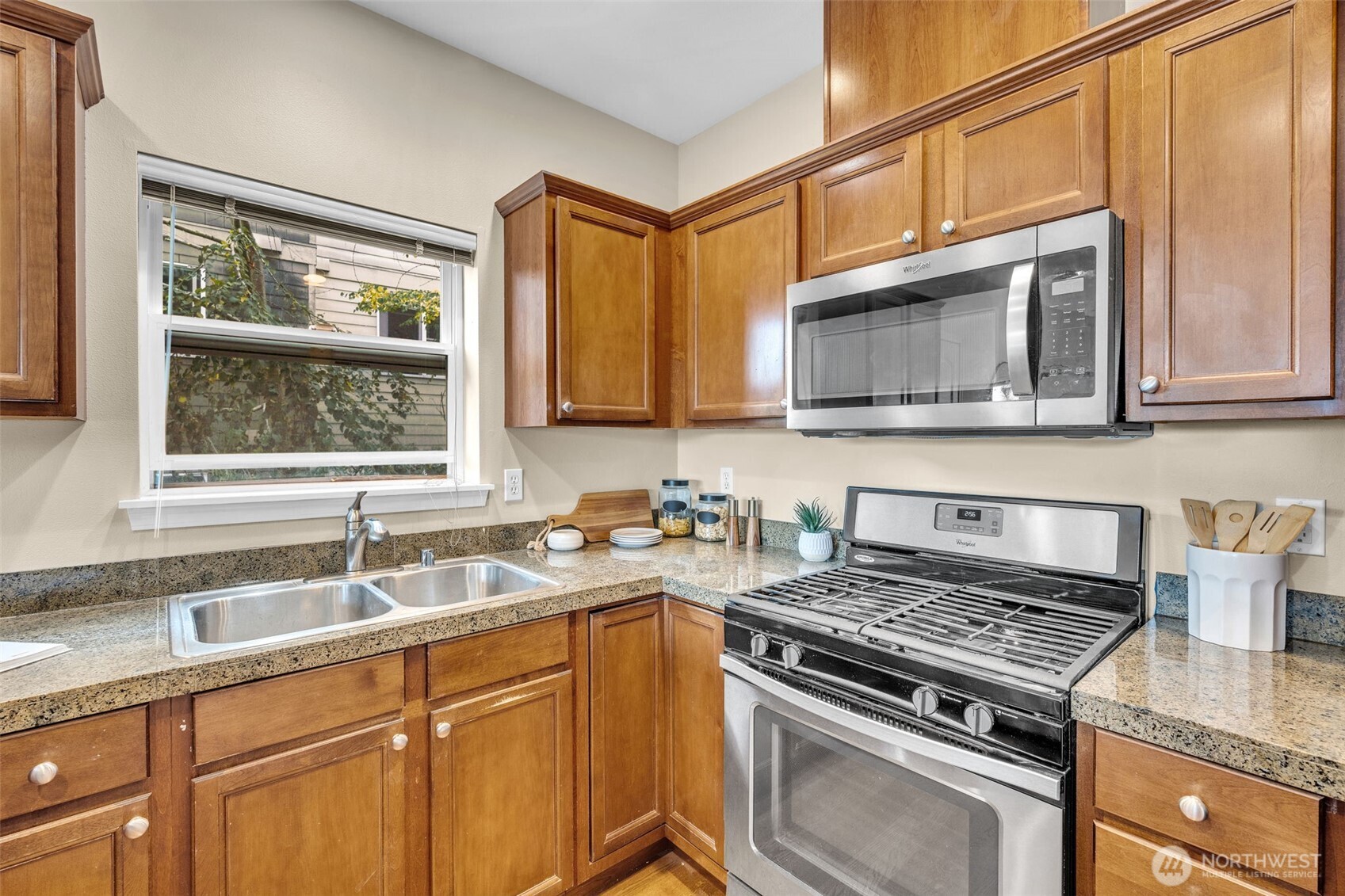 3112 Southwest Avalon Way, Unit 302 Seattle, WA 98126 - Photo 11 of 40 a kitchen with stainless steel appliances granite countertop a sink stove and microwave