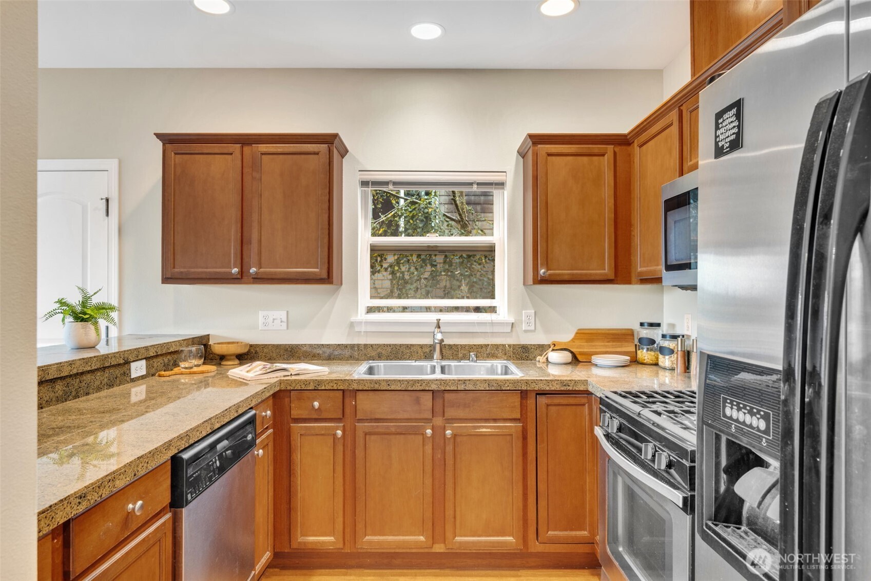 3112 Southwest Avalon Way, Unit 302 Seattle, WA 98126 - Photo 8 of 40 a kitchen with stainless steel appliances granite countertop a sink stove and refrigerator