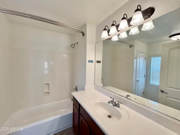 a bathroom with a sink mirror and a bathtub