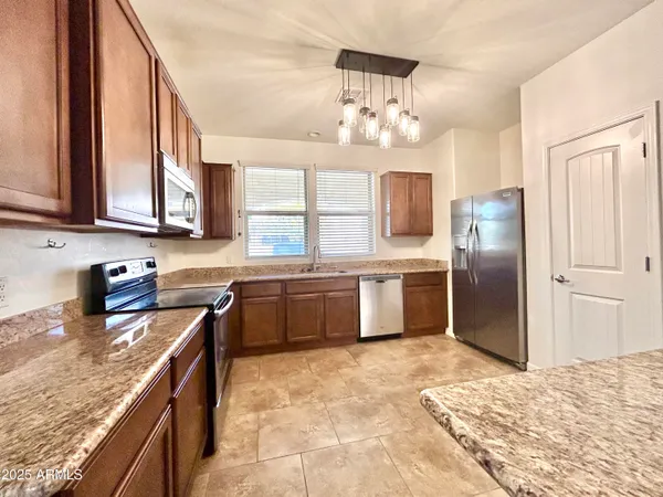 a kitchen with stainless steel appliances granite countertop a stove refrigerator and cabinets