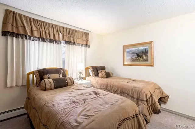 a bedroom with two beds and a large window