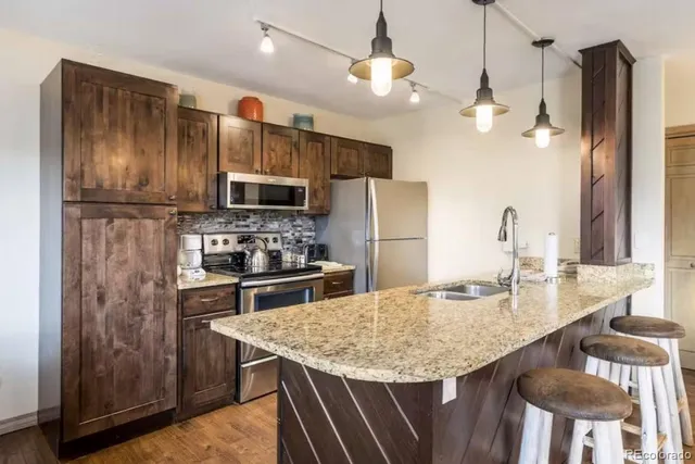 a kitchen with kitchen island a refrigerator stove and microwave