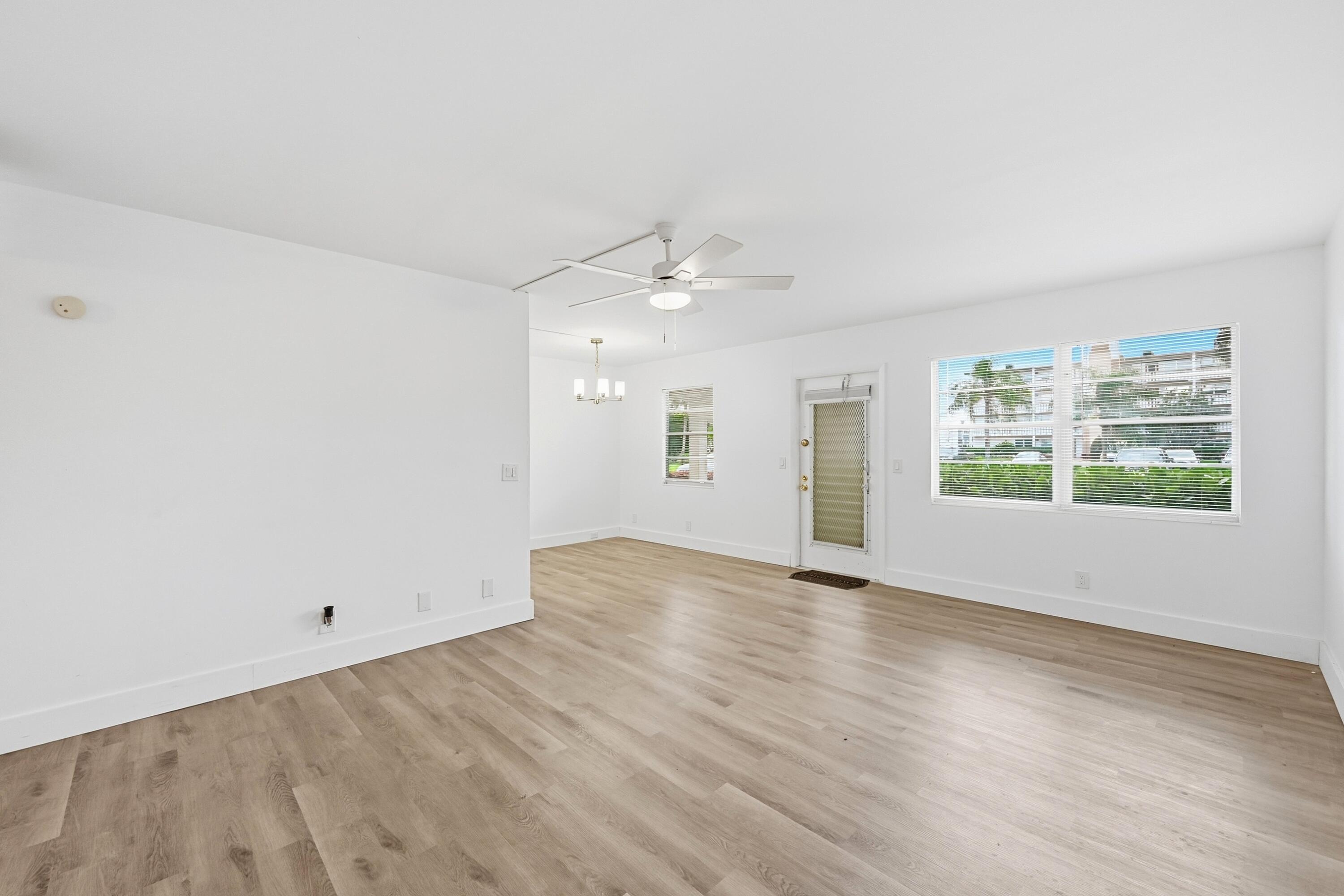 1043 Cornwall C Boca Raton, FL 33434 - Photo 3 of 34 wooden floor in an empty room with a window
