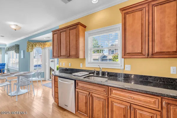 a kitchen with stainless steel appliances granite countertop a sink a stove and cabinets