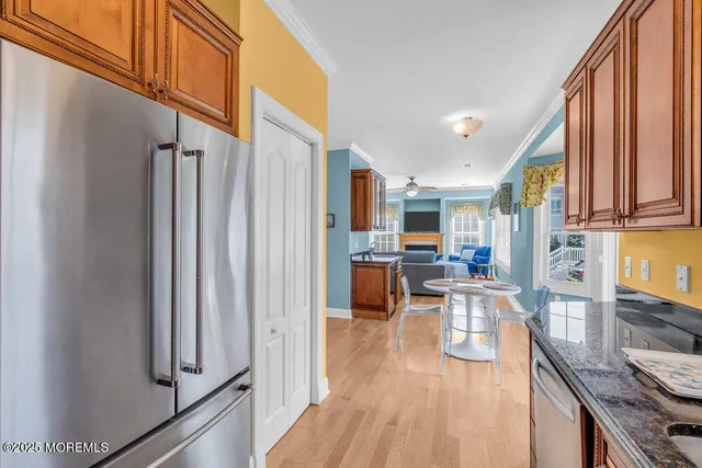 a living room with stainless steel appliances furniture a rug and a kitchen view
