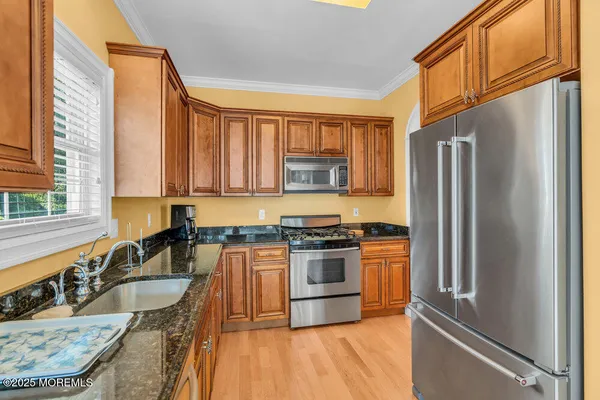 a kitchen with granite countertop a sink stove and refrigerator