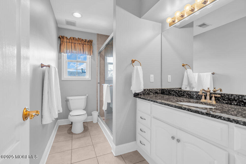 419 Central Avenue Spring Lake, NJ 07762 - Photo 30 of 41 a bathroom with a granite countertop sink a toilet and a blue shower