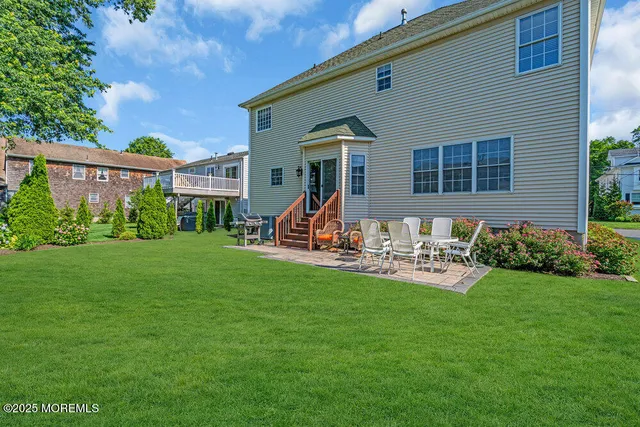 a view of a house with backyard and a tree