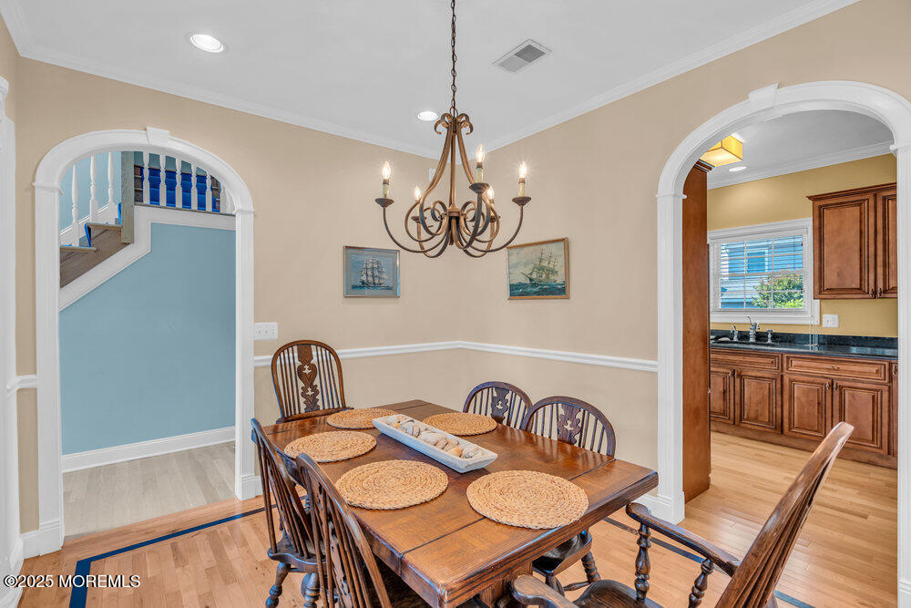419 Central Avenue Spring Lake, NJ 07762 - Photo 9 of 41 a dining room with furniture a chandelier and wooden floor