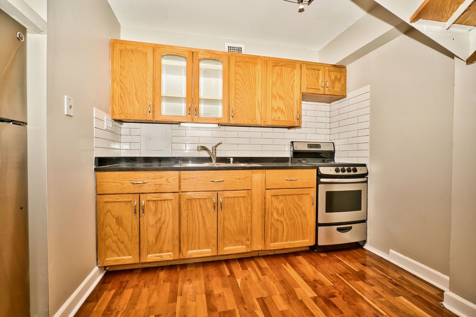 6166 North Sheridan Road, Unit 26A Chicago, IL 60660 - Photo 12 of 27 a kitchen with granite countertop white cabinets and white appliances