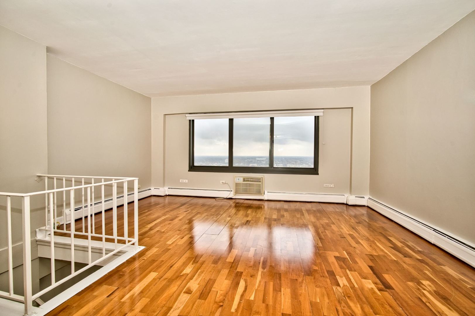 6166 North Sheridan Road, Unit 26A Chicago, IL 60660 - Photo 17 of 27 a view of an empty room with wooden floor and a window