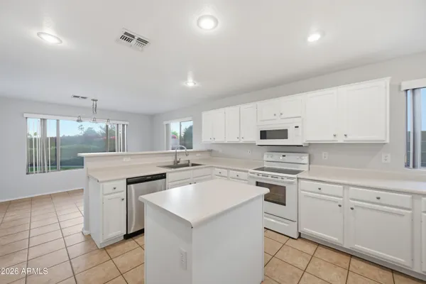 a kitchen with a sink window and cabinets