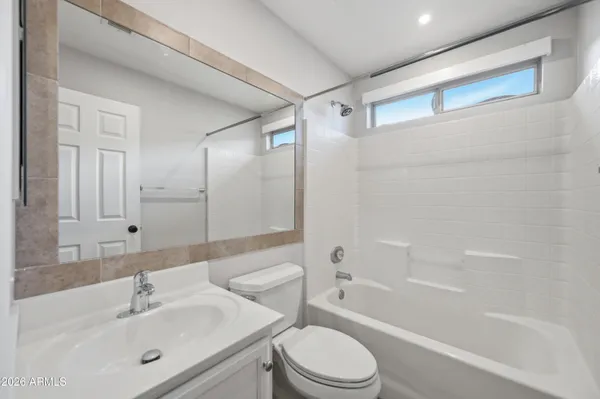 a bathroom with a bathtub shower sink vanity and toilet