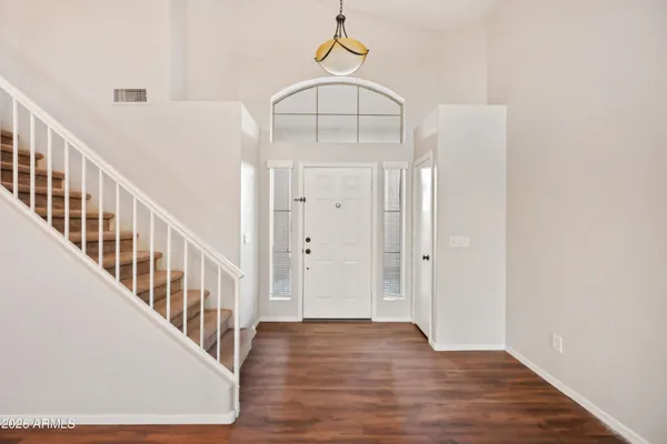 a view of a hallway with wooden floor and staircase