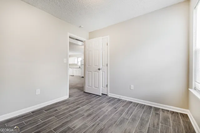 an empty room with wooden floor and a window