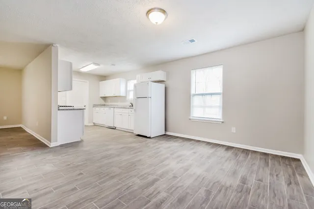 a view of kitchen with wooden floor and electronic appliances