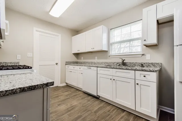 a kitchen with granite countertop cabinets stainless steel appliances and a window