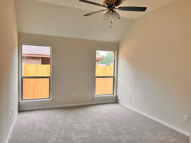 an empty room with a window and a fan