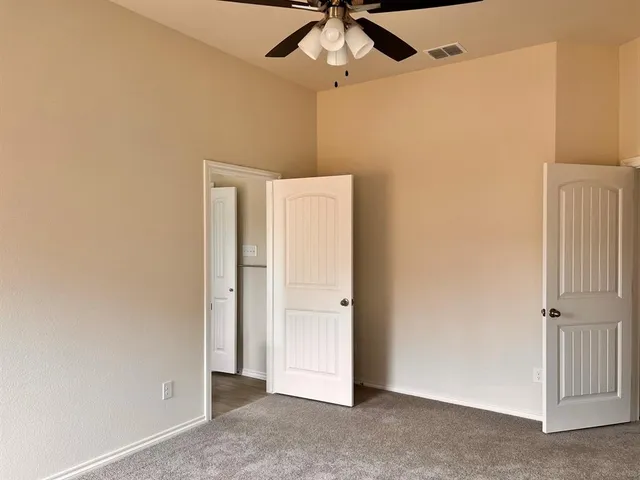 a view of empty room with ceiling fan