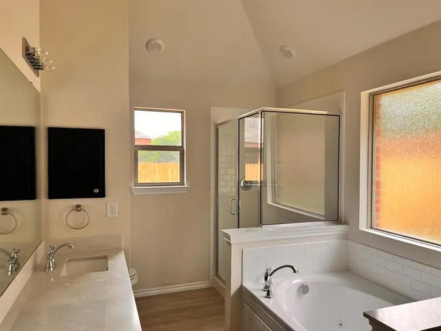 a bathroom with a tub sink and mirror