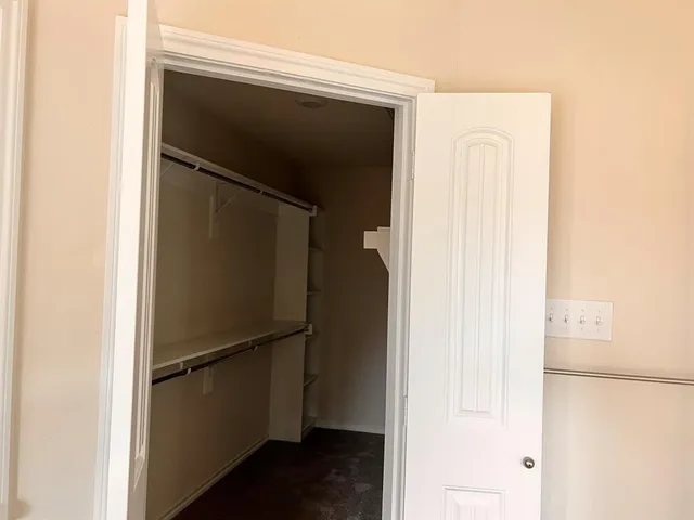 a view of walk in closet with empty racks