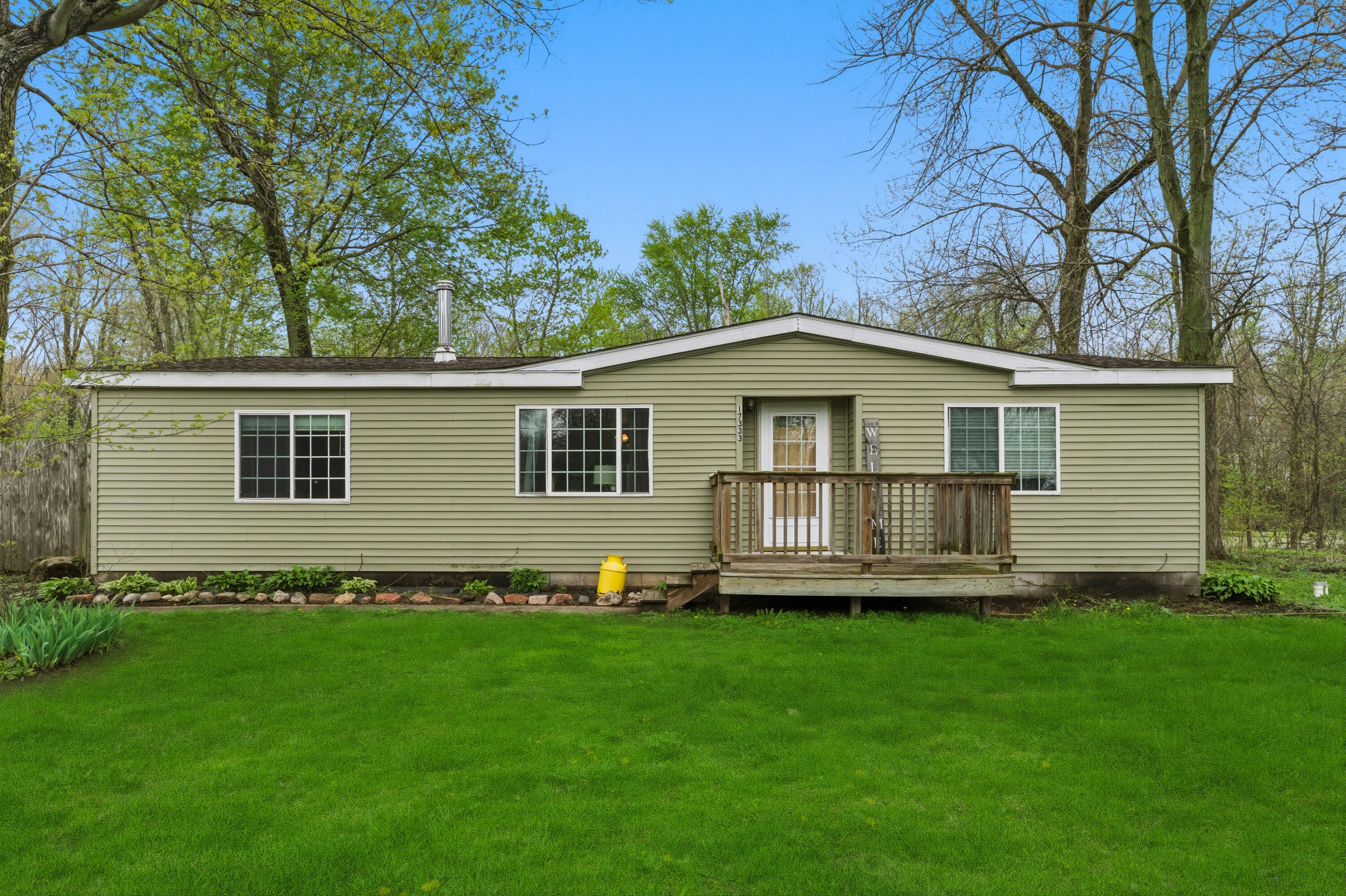 a front view of a house with a yard and trees