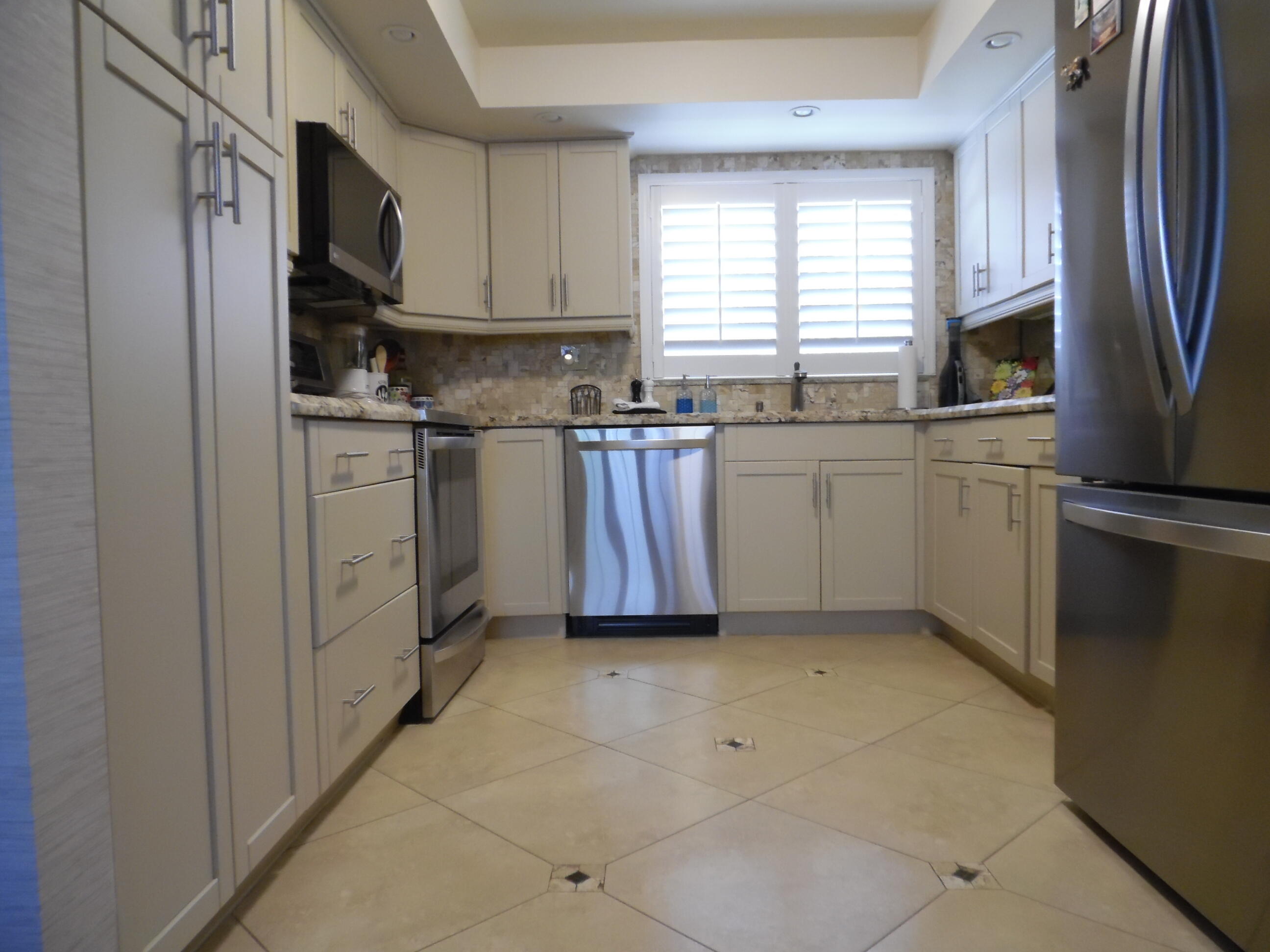157 Capri East Delray Beach, FL 33484 - Photo 4 of 20 a kitchen with stainless steel appliances granite countertop a refrigerator sink and stove