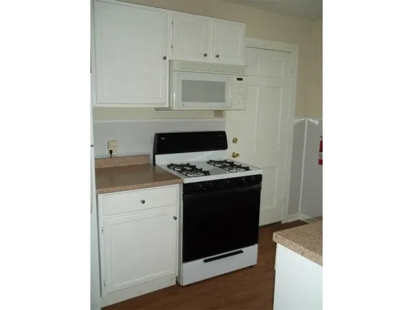 a kitchen with granite countertop white cabinets and appliances