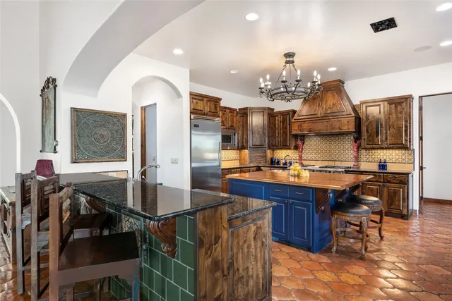 a kitchen with stainless steel appliances granite countertop a sink a stove and a refrigerator