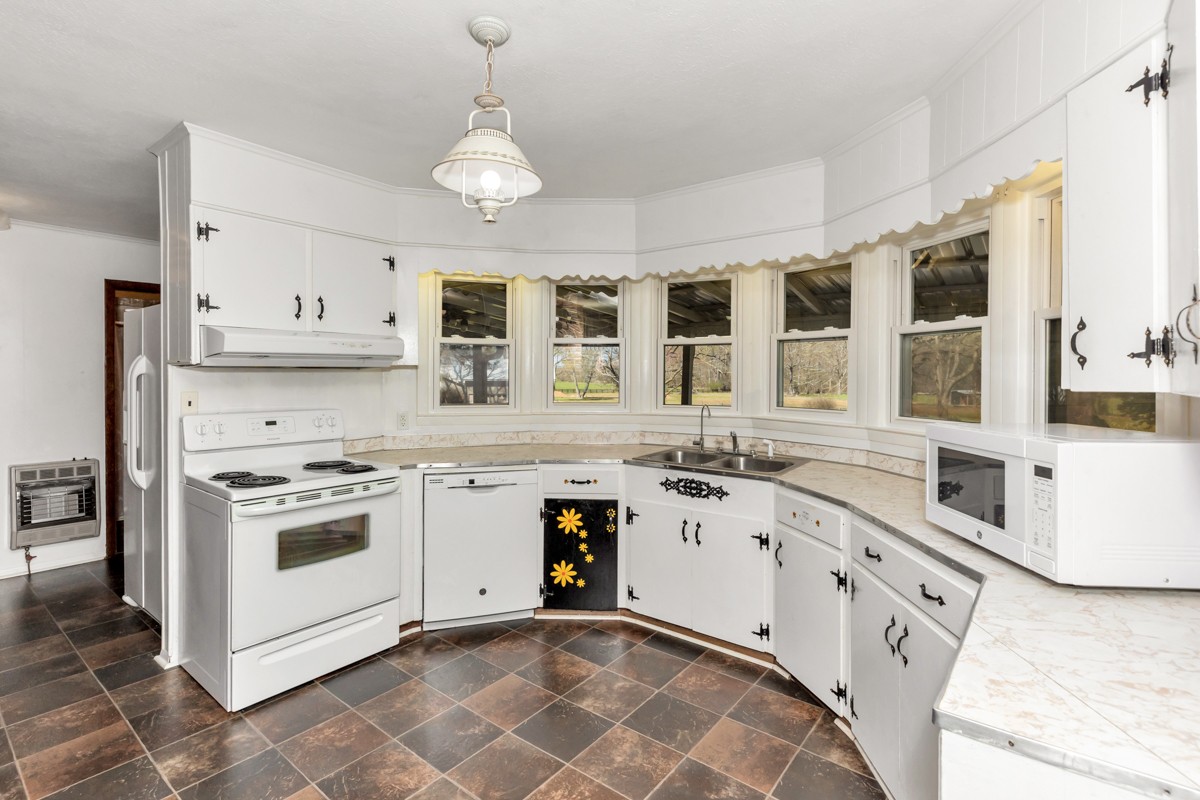 24 Slaughter Pen Road Ardmore, TN 38449 - Photo 7 of 32 a kitchen with granite countertop white cabinets and white appliances