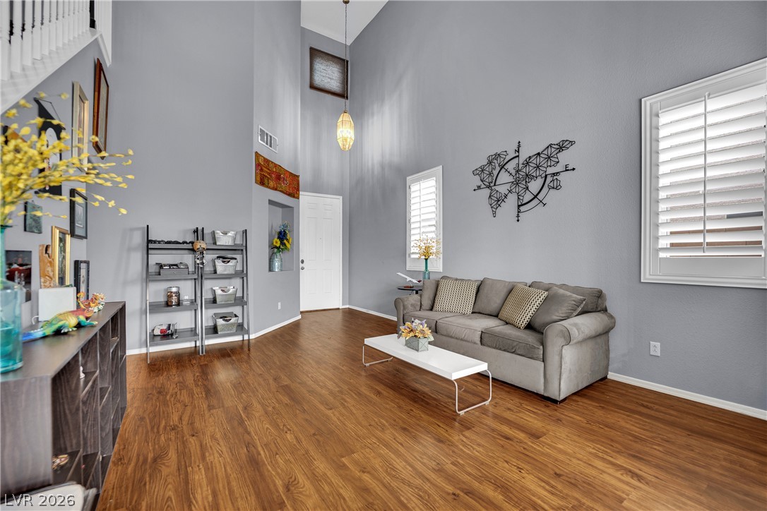 1724 Millstream Way Henderson, NV 89074 - Photo 9 of 60 A welcoming living area showcases high ceilings and rich wood flooring, perfect for relaxation.