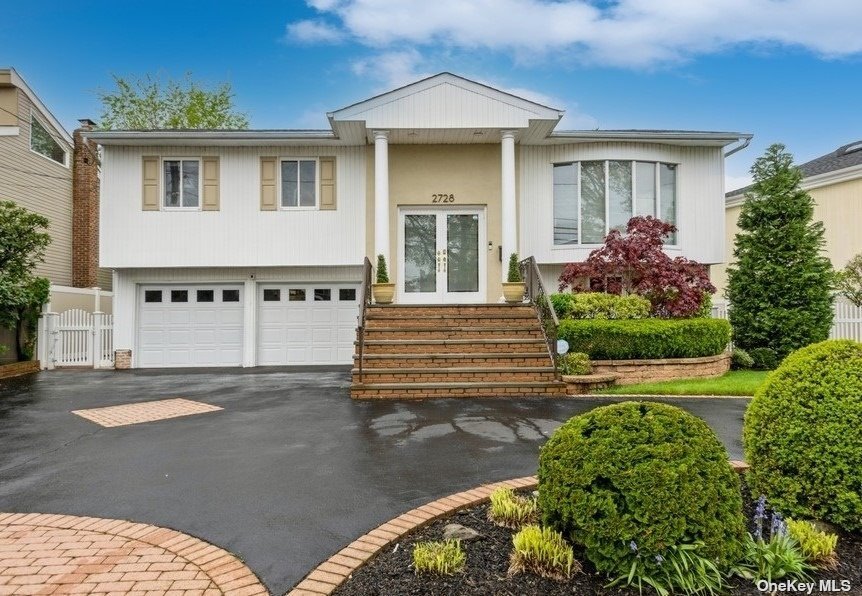 2728 Clubhouse Road Merrick, NY 11566 - Photo 1 of 1 a front view of a house with a yard and potted plants