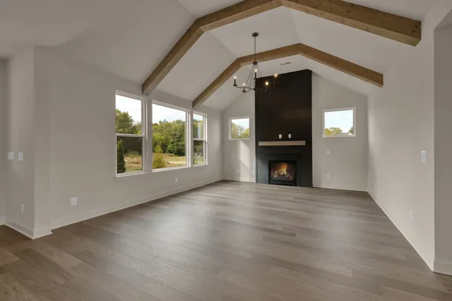 an empty room with wooden floor and a window